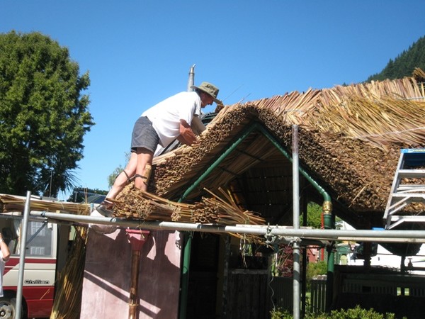 Leo van Midden works with tied bundles of dried flax to thatch the roof of a new BBQ area at Queenstown's Top 10 Holiday Park "Creeksyde" in traditional Dutch style